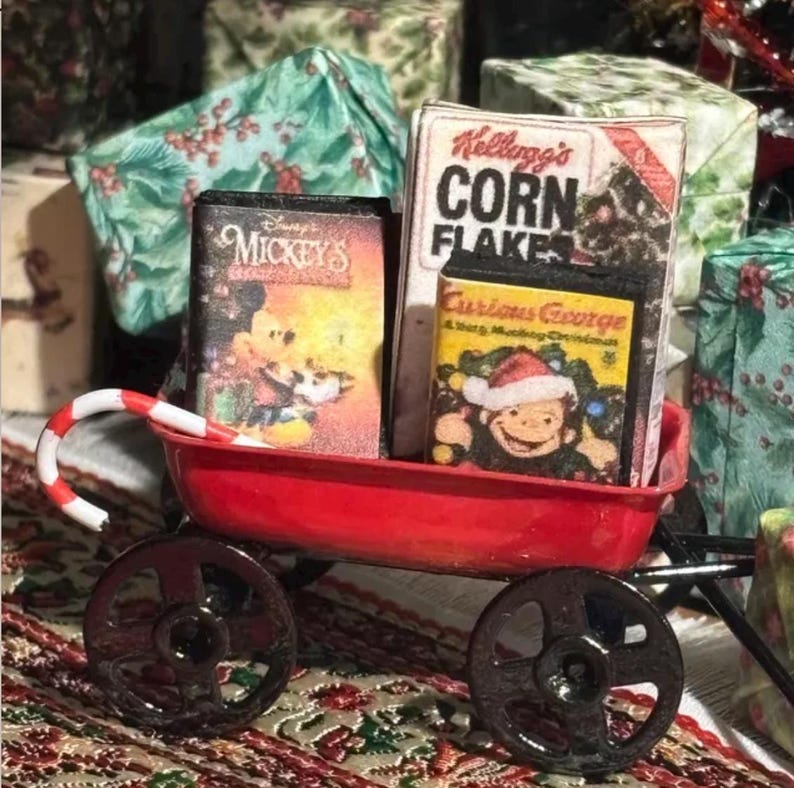 Pu&ograve; includere: Un carretto rosso in miniatura in metallo che trasporta una scatola di Kellogg's Corn Flakes, una videocassetta di Mickey's Christmas Carol e una di Curious George A Very Monkey Christmas, con un bastoncino di zucchero sul bordo.