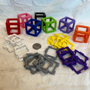 May include: A set of colorful plastic building blocks in various colors, including red, blue, green, yellow, purple, orange, pink, white, and gray. The blocks are in the shape of cubes and squares.