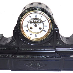 May include: A black and green marble mantel clock with a white face and gold hands. The clock has a decorative base with a diamond-shaped design.