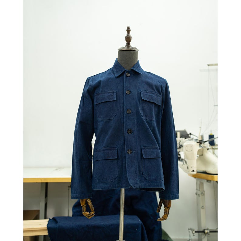 May include: A dark blue denim jacket with a button-up front, four pockets, and long sleeves.