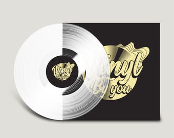 May include: A clear vinyl record with a black center label featuring the gold text Vinyl By you. The record is positioned in front of a black square sleeve that displays a large gold circular graphic with the text Vinyl By you in script.
