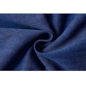 May include: Close-up of a deep blue fabric with a herringbone weave pattern. The fabric is folded, creating soft curves and shadows. The texture appears to be a medium weight, suitable for apparel or home decor.