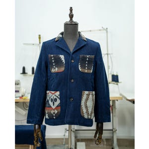 May include: A navy blue jacket with a button-up front and four patch pockets. The pockets are lined with a colorful geometric pattern.