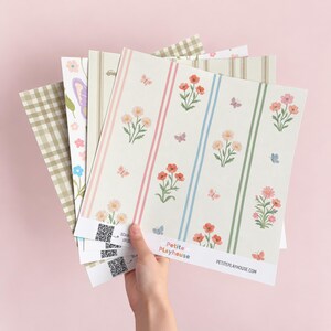 May include: A collection of patterned paper sheets featuring floral designs, butterflies, and stripes in soft pastel colors. The sheets include a QR code and the text Petite Playhouse and PETITEPLAYHOUSE.COM printed at the bottom edge.