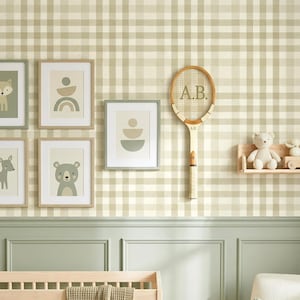 May include: A nursery wall with framed animal art, a vintage tennis racket with "A.B." on the strings, and a small shelf with a teddy bear. The wall has a green and white checkered pattern, with a light green wainscoting and a wooden crib.