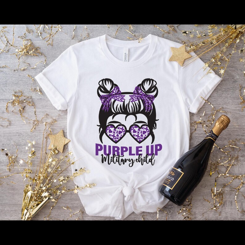 Peut inclure: T-shirt blanc avec un graphique violet d'une fille avec des couettes portant des lunettes de soleil et le texte "Purple Up Military Child".