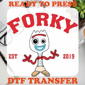 May include: Red and white graphic design with the text "Forky" in red letters. The design also includes the text "EST 2019" and "DTF TRANSFER". The graphic features a cartoon character of Forky from the Toy Story movie.