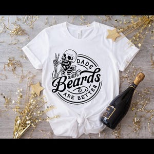 K&ouml;nnte beinhalten: Wei&szlig;es T-Shirt mit einem schwarz-wei&szlig;en Grafikdesign eines Skeletts mit Bart und dem Text "Dads with Beards are Better".