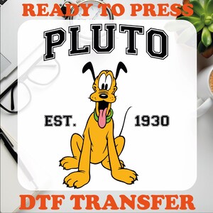 May include: Ready to press DTF transfer featuring Pluto, a yellow cartoon dog with a green collar and a red tongue, with the text "PLUTO" in black block letters above him and "EST. 1930" in black block letters below him.