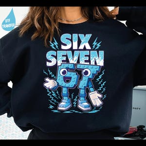 May include: Black sweatshirt with the words "SIX SEVEN" in light blue and white. The numbers 6 and 7 are depicted as cartoon characters with blue bodies, white gloves, and shoes. Lightning bolt graphics surround the text and characters.