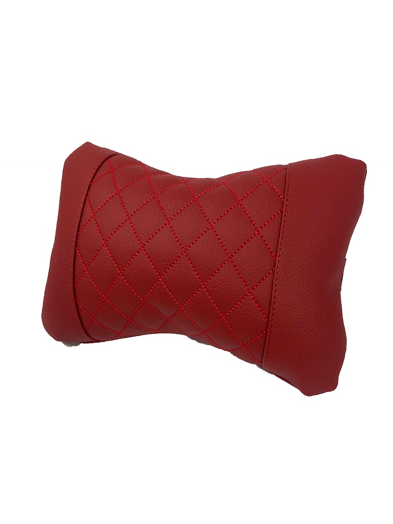 May include: Red quilted neck pillow with diamond stitching.