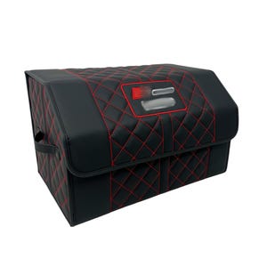 May include: Black storage container with red diamond stitching. The container has a rectangular shape with a handle on the side. The top features a red and silver emblem.