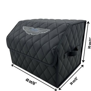 May include: Black quilted car trunk organizer with a silver emblem. The organizer is 16 inches long, 12 inches wide, and 12 inches high. It features a diamond pattern and a handle for easy carrying.