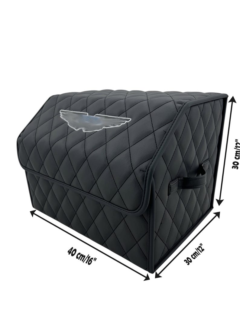 May include: Black quilted car trunk organizer with a silver emblem. The organizer is 16 inches long, 12 inches wide, and 12 inches high. It features a diamond pattern and a handle for easy carrying.