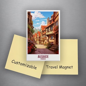 May include: A rectangular travel magnet featuring a colorful illustration of a street scene in Alsace, France. The magnet has the word "ALSACE" and "FRANCE" printed on it. Two yellow sticky notes are below the magnet with the words "Customizable" and "Travel Magnet".
