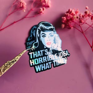 May include: A sticker featuring a retro-style illustration of a woman holding a telephone. The sticker has the text "THAT'S A HORRIBLE IDEA, WHAT TIME?" in white. The sticker has a holographic effect and is held by tweezers.