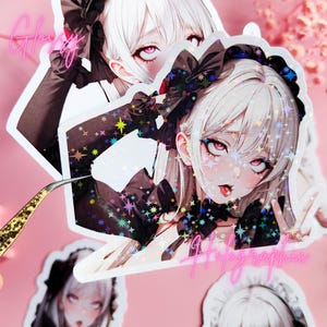 以下が含まれることがあります： 白髪の女性が黒と白のメイド服を着ているアニメスタイルのイラストが描かれたホログラフィックステッカー4枚。ステッカーはキラキラと虹色に光る仕上げになっています。