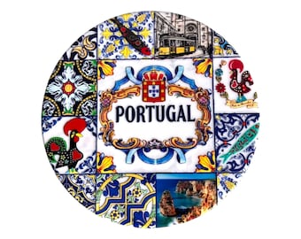 May include: Round ceramic tile featuring a collage of Portuguese imagery. The design includes a yellow tram, a rooster, and the word "PORTUGAL" in a decorative frame. The tile has a white background with blue and yellow floral patterns.