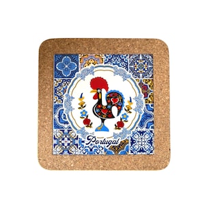 May include: Square cork coaster featuring a colorful rooster design, a symbol of Portugal. The rooster is black with red, blue, and yellow accents, surrounded by a white circle with blue floral patterns. The word "Portugal" is written in blue.