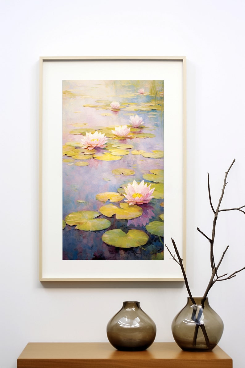 May include: A framed painting of pink water lilies in a pond with green lily pads. The painting is in a light wood frame and is hanging on a white wall.
