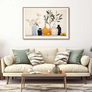May include: A framed watercolor painting of a still life with a variety of vases and branches with yellow flowers and green leaves. The vases are in shades of blue, black, yellow, and white. The painting is hanging on a white wall above a white couch with green and striped pillows.