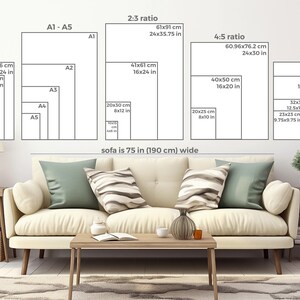 May include: A white sofa with two pillows, a coffee table, and a side table with a lamp and a vase. The wall behind the sofa has a diagram showing different paper sizes and their dimensions in inches and centimeters. The text on the wall reads "sofa is 75 in (190 cm) wide".