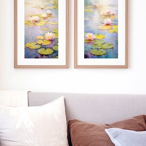 May include: Two framed paintings of water lilies in a pond. The paintings are in a light wood frame and feature pink water lilies with green lily pads and blue water.