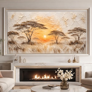 May include: A large rectangular wall art piece featuring a textured impasto painting of an African savanna landscape at sunset. The scene depicts several acacia trees silhouetted against a bright orange sun, with thick, raised paint strokes in shades of cream, gold, and brown creating a tactile, layered effect across the entire canvas.