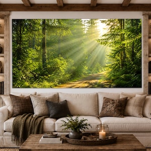 Puede incluir: Un gran cuadro rectangular de pared que representa un sendero forestal soleado con árboles de color verde vibrante y rayos de luz dorados que se filtran a través del dosel, montado sobre un sofá beige con cojines marrones y una mesa.