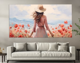 Può includere: Una grande stampa su tela raffigura una persona con un vestito rosa e un cappello di paglia, in piedi in un campo di papaveri rossi. L'opera d'arte ha uno stile morbido e pittorico, con uno sfondo di montagne blu e un cielo nuvoloso. La stampa è esposta sopra un divano bianco.