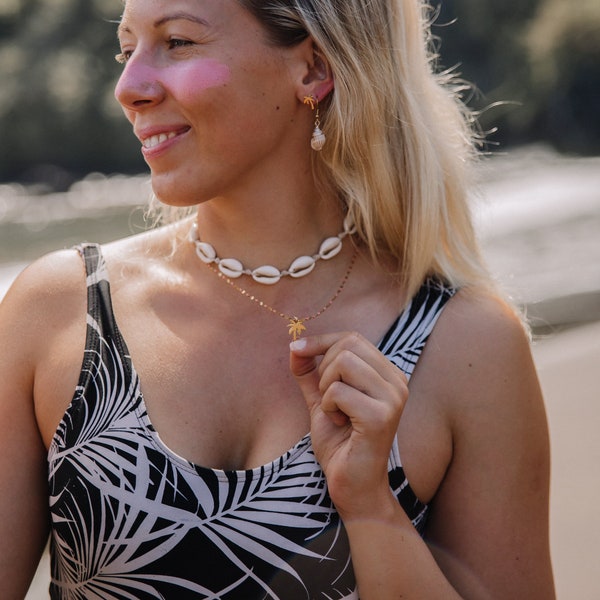 Choker made of KAURI shells and a white strap and a chain made of surgical stainless steel, adjustable clasp.