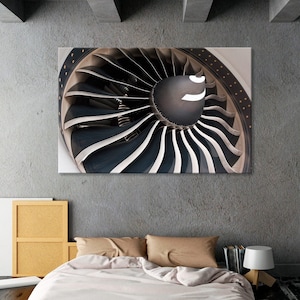 Puede incluir: Primer plano de un motor de avión de color gris y negro. El motor está enmarcado por una pared blanca y una cama con ropa de cama blanca y almohadas marrones.