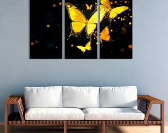 May include: A three-panel canvas artwork showcasing golden butterflies on a black backdrop with bokeh. The butterflies have detailed wing patterns, creating a striking contrast. The artwork is displayed above a wooden sofa with white cushions.