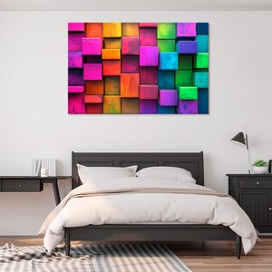May include: Abstract wall art featuring a colorful geometric pattern of stacked squares in shades of red, orange, yellow, green, blue, purple, and pink.