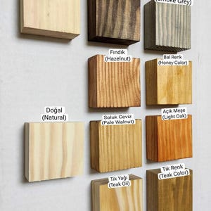 K&ouml;nnte beinhalten: Eine Sammlung von Holzbl&ouml;cken, die verschiedene Holzbeizfarben zeigen. Die Bl&ouml;cke sind mit Namen wie "Transparent Teak Oil", "Dark Walnut" und "Smoke Grey" beschriftet. Das Bild zeigt die verschiedenen Farbt&ouml;ne und Oberfl&auml;chen f&uuml;r Holzprojekte.