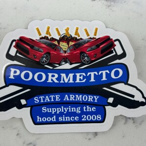 May include: A white sticker with a blue banner that says "POORMETTO STATE ARMORY Supplying the hood since 2008". The banner is flanked by two red Dodge Charger cars with gold bottles on top.