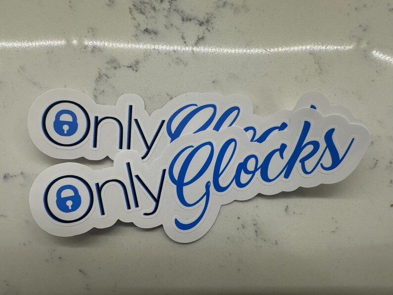 May include: Two white stickers with blue text and a blue padlock icon. The text on the stickers reads "Only Glocks".