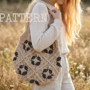 Puede incluir: Un bolso tote de crochet beige con un estampado floral marrón oscuro se lleva sobre el hombro. La palabra "PATTERN" está impresa en letras blancas grandes en la parte superior izquierda. El bolso se lleva con un suéter color crema y pantalones claros.