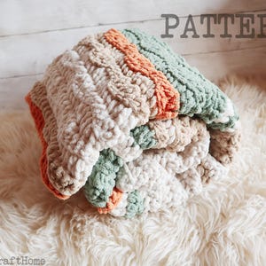 May include: A folded chunky crochet blanket featuring a textured cable knit pattern in alternating stripes of sage green, burnt orange, cream, and beige yarn. The word PATTERN is printed in the upper right corner and ArticraftHome in the bottom left.