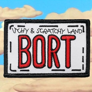 May include: Embroidered patch featuring the word "BORT" in large, red, bold letters. The patch has a white background with a black border and the text "ITCHY & SCRATCHY LAND" above the word "BORT".