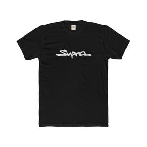 May include: Black t-shirt with the white word "Supra" in a cursive font across the chest. The shirt has a crew neck and short sleeves. The fabric appears to be a soft cotton blend.