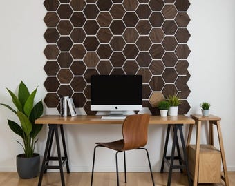 May include: A modern home office setup featuring a wooden desk with a computer, chair, and potted plants. The wall behind the desk is decorated with a honeycomb pattern of dark wood tiles. The room has a minimalist design with natural light.