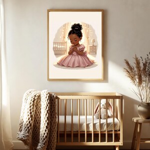 May include: A framed print of a young girl in a pink dress, kneeling in prayer. The artwork has a soft, warm color palette and is set in a nursery with a crib and a nightstand. A wooden crib with a beige blanket and a stuffed bunny is in the foreground.