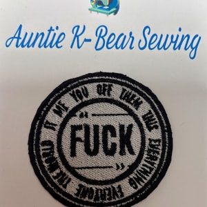 May include: Embroidered patch with the word "FUCK" in the center, surrounded by text that reads "It Me You Off Them Time Everything Everyone". The patch is black and gray, with a circular design. The image also includes the text "Auntie K-Bear Sewing".