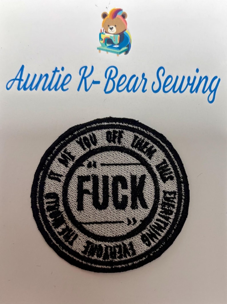 May include: Embroidered patch with the word "FUCK" in the center, surrounded by text that reads "It Me You Off Them Time Everything Everyone". The patch is black and gray, with a circular design. The image also includes the text "Auntie K-Bear Sewing".