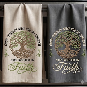 May include: Two rectangular kitchen towels, one beige and one dark grey, each featuring a brown tree illustration with green leaves. The text reads: Grow through what you go through, stay rooted in Faith. The design is centred on each fabric towel.
