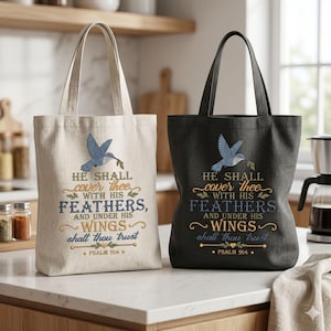 May include: Two tote bags, one cream and one black, each featuring a blue hummingbird illustration and the text: He shall cover thee with his feathers, and under his wings shalt thou trust, Psalm 91:4, printed in blue and gold lettering.
