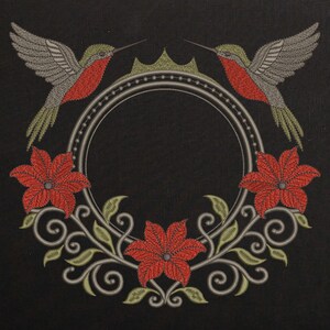 May include: Embroidered design on black fabric featuring two hummingbirds, red flowers, and a circular frame. The hummingbirds have grey wings, red throats, and green heads. The flowers are red, and the frame is silver with a green crown.