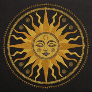 May include: Embroidered sun design in shades of gold and yellow on a black background. The sun has a smiling face with closed eyes and a third eye. A decorative border surrounds the sun, with spiral accents.