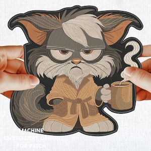 Op de afbeelding: Geborduurde patch van een chagrijnige kat die een bruine badjas draagt en een stomende mok koffie vasthoudt. De kat heeft een witte vlek op zijn kop en kijkt recht naar de kijker.